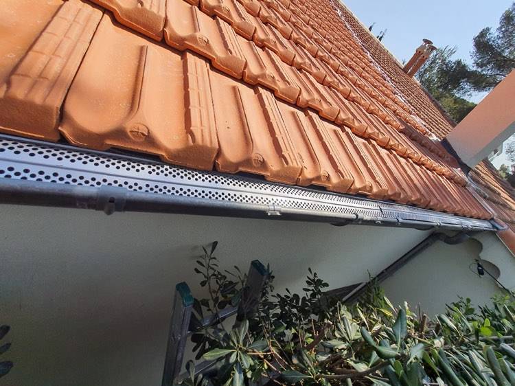 Pose de grilles pares feuilles sur le bord des gouttières pour éviter l'accumulation de déchets végétaux et le bouchage de gouttières à Antibes dans les Alpes Maritimes